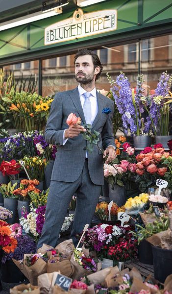 Gentleman im Anzug kauft Blumen