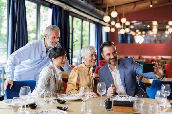 Group of friends taking a selfie in a stylish restaurant